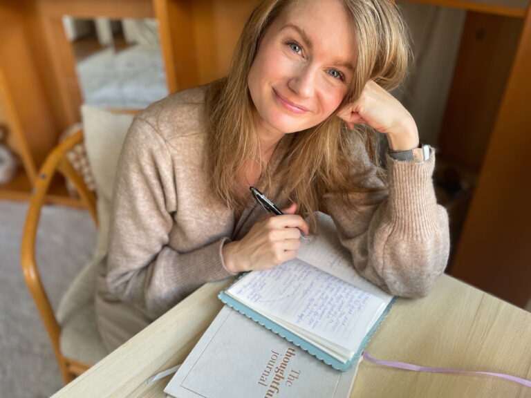 Josefine Berg skriver i sin dagbok vid köksbordet och ler